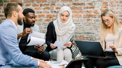 Young multiethnic business colleagues sitting around a conference room table