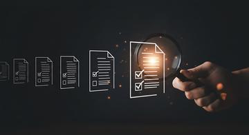 hand using magnifying glass to inspect digital checklist icons
