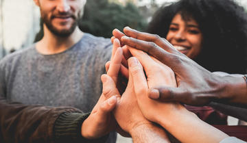 hands all coming together in a high five circle