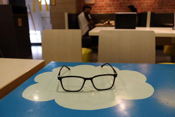 eyeglasses laying on top of salesforce logo on desk