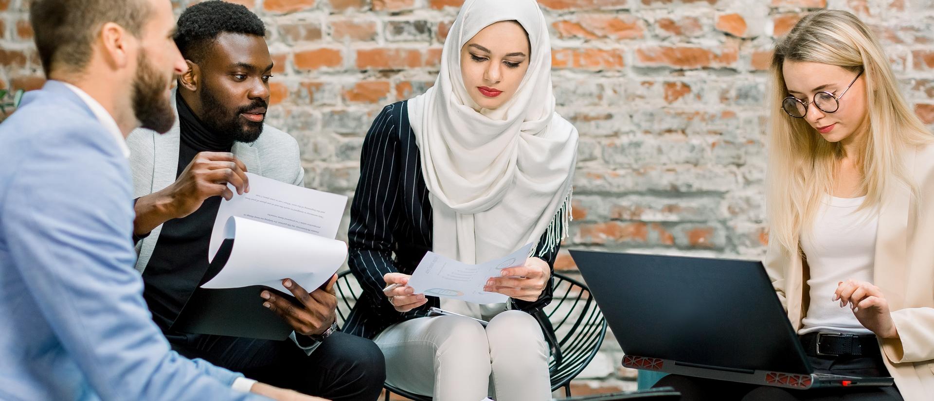 Young multiethnic business colleagues sitting around a conference room table